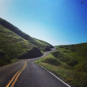 Winding road and green rolling hills. 
